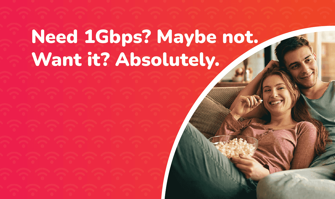 Gigabit Broadband Explained: Do You Really Need 1Gbps Speeds in the UK? Couple relaxing on the sofa streaming online with popcorn, alongside text reading “Need 1Gbps? Maybe not. Want it? Absolutely.” promoting Fusion Fibre Group’s gigabit broadband speeds.