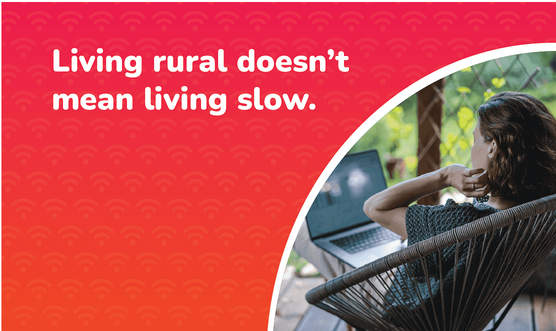 Woman using a laptop at home in a rural setting with the text “Living rural doesn’t mean living slow” promoting full fibre broadband for rural areas.