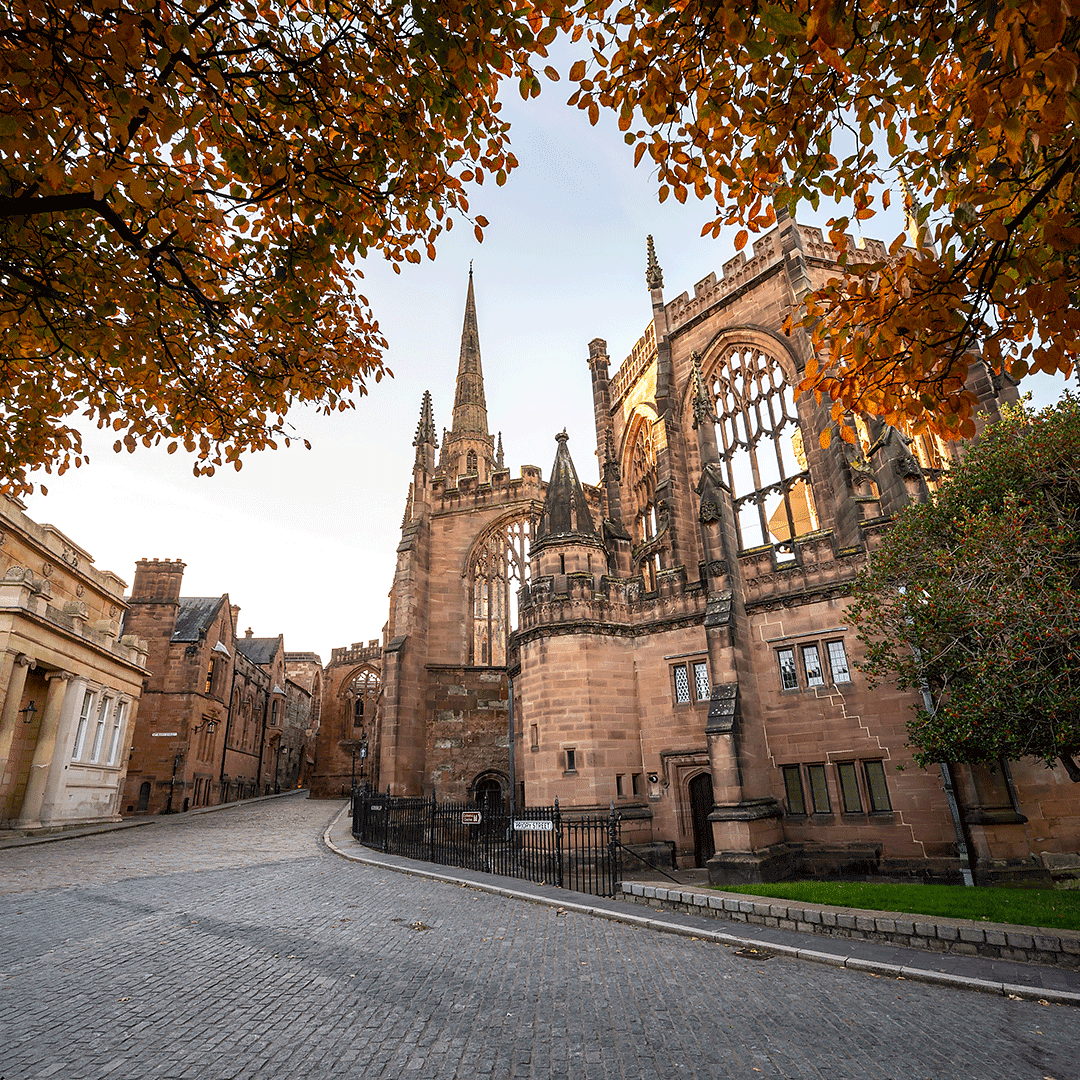 Historic Coventry Cathedral ruins surrounded by autumn leaves in Coventry city centre, West Midlands