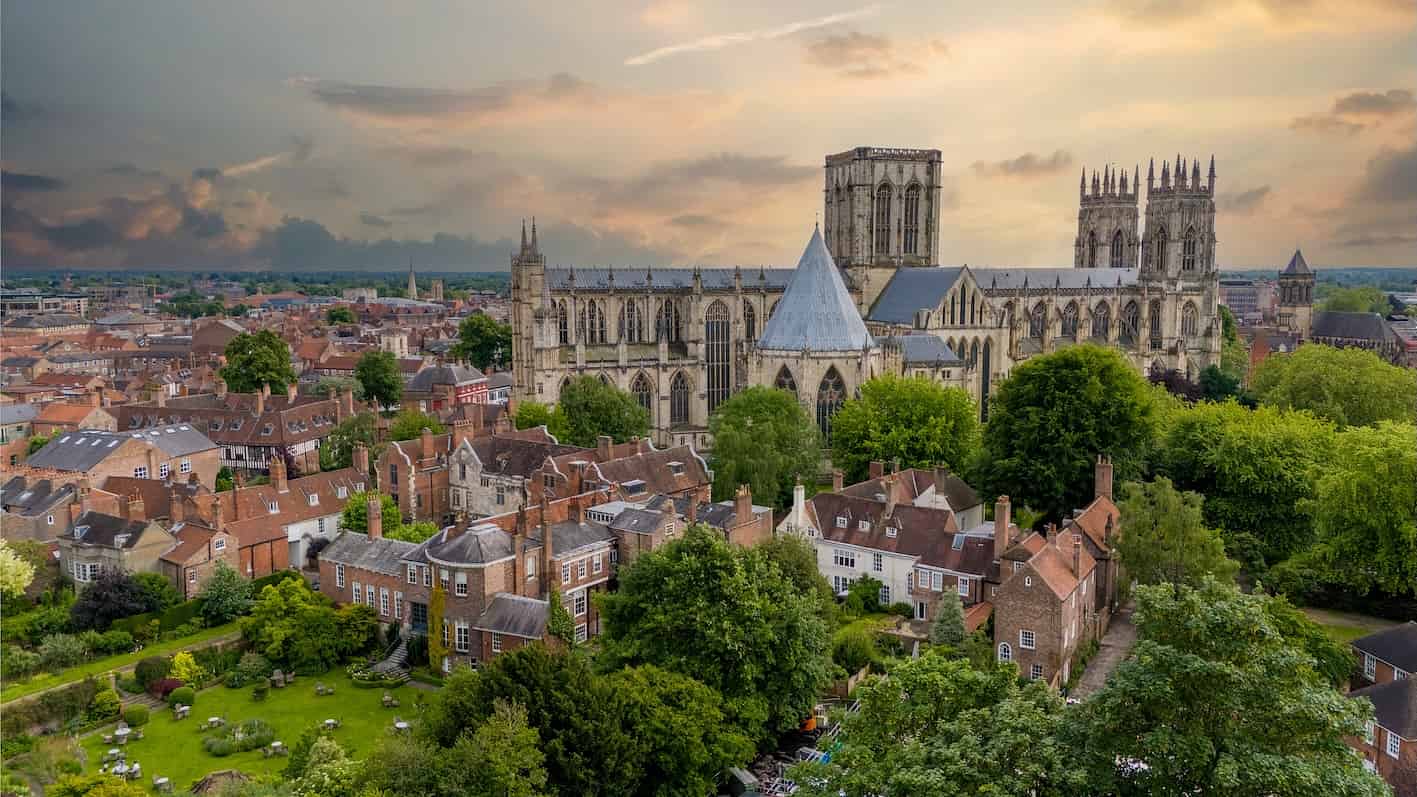 Full Fibre Broadband in York and Surrounding Villages  Aerial view of York Minster and the historic city centre surrounded by rooftops and trees at sunset in York, England.